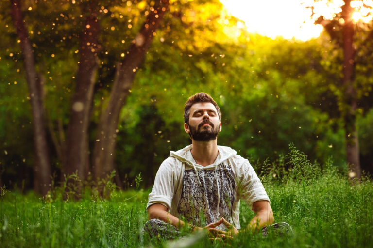 A,Bearded,Man,Is,Meditating,On,Green,Grass,In,The